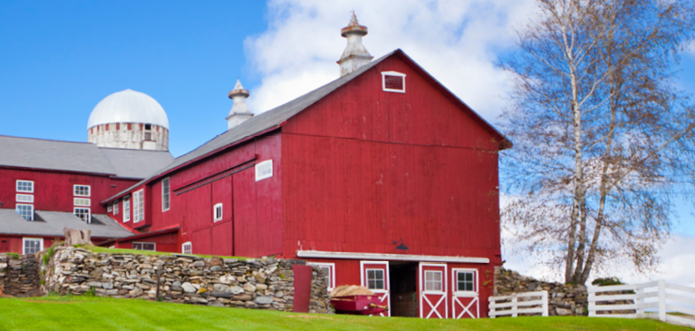 Red barn with blue sky and green grass